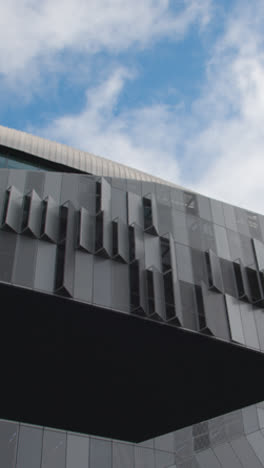 Vertical-Video-Looking-Up-At-Exterior-Of-Tottenham-Hotspur-Stadium-The-Home-Ground-Of-Spurs-Football-Club-In-London